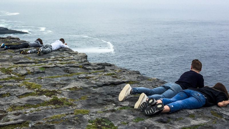 People looking over the edge of a cliff