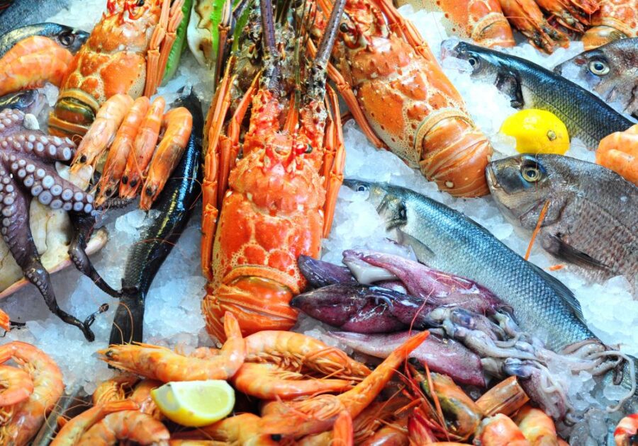 Various types of seafood are on display in the market.