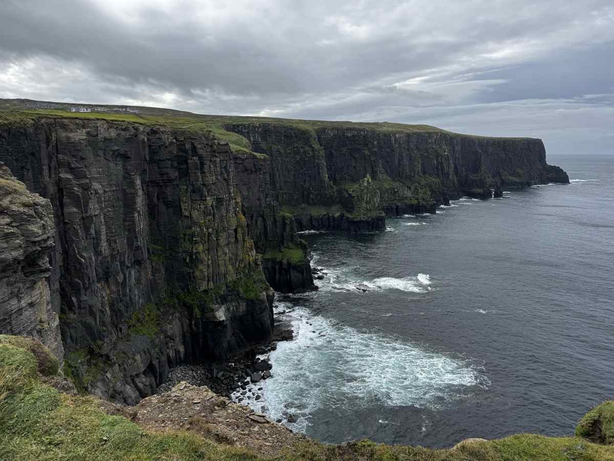 Dramatic sea cliffs stretching into the Atlantic under a stormy sky