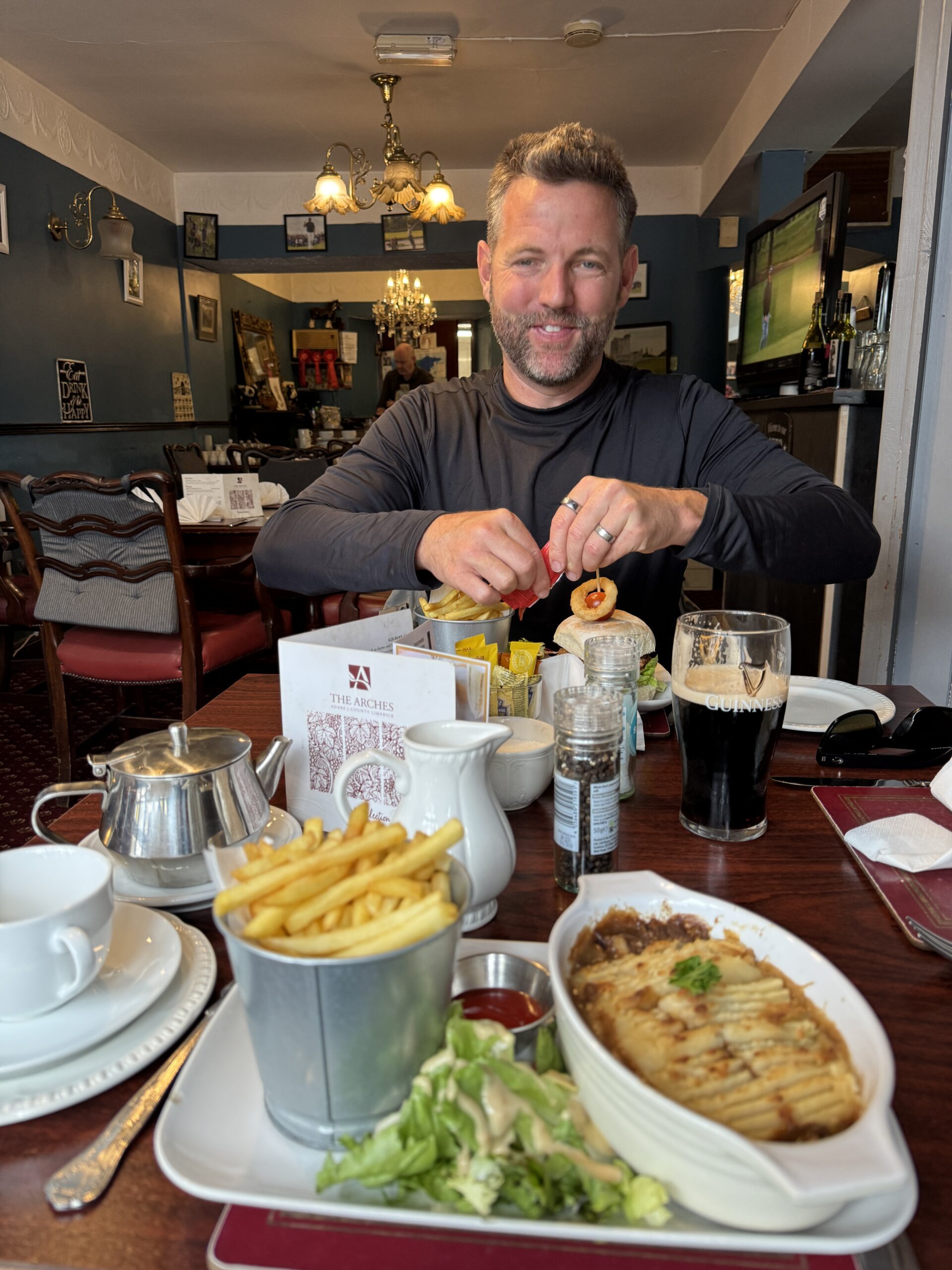 Man enjoying a pub lunch with fish pie, chips and Guinness at a restaurant in Adare, County Limerick