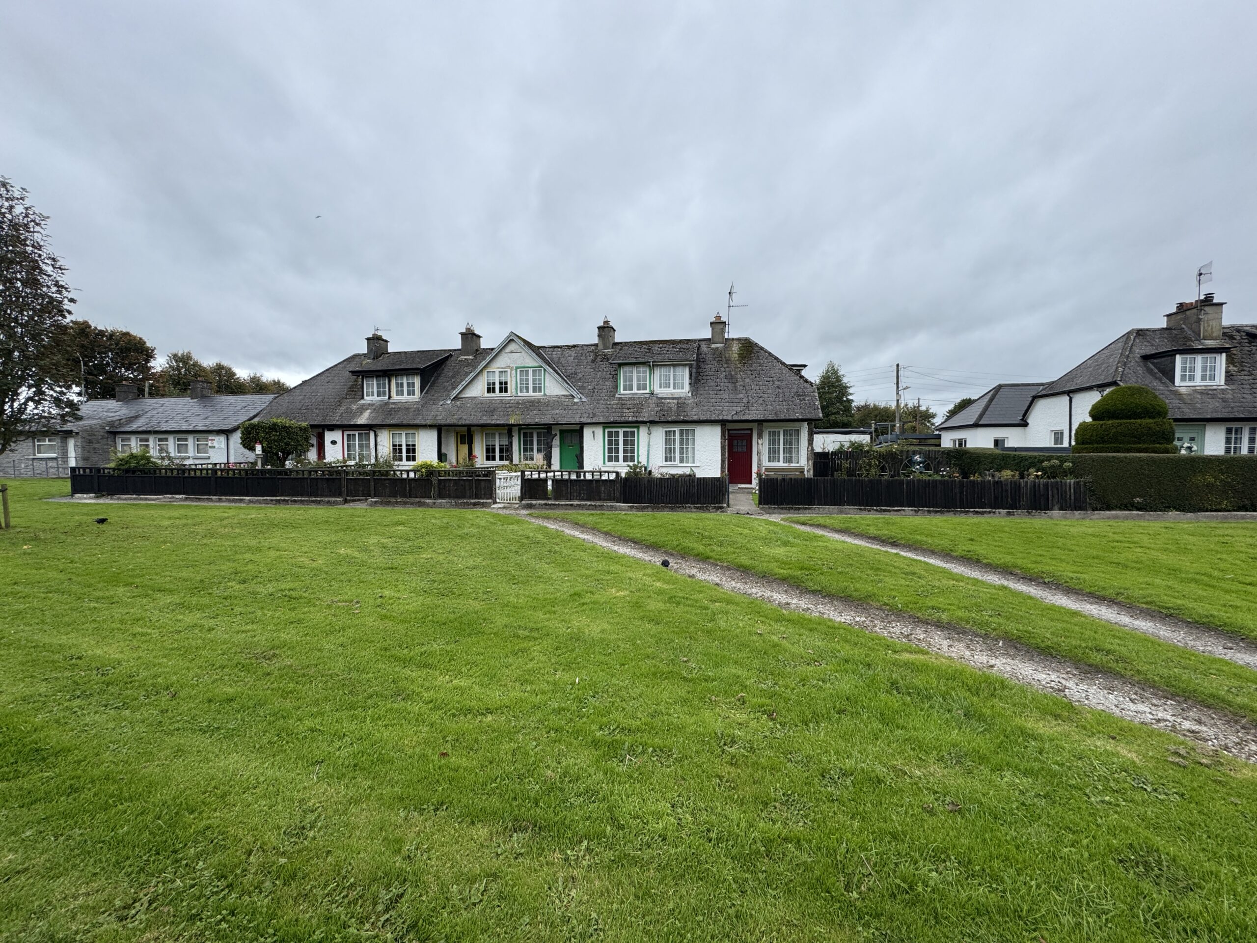 Row of charming cottages with green and red doors on Rathkeale Road near Adare, Ireland