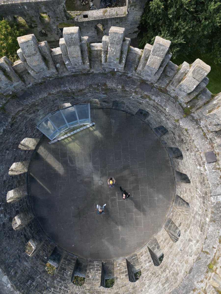 Aerial view inside circular medieval castle tower with battlements and tourists, Ireland