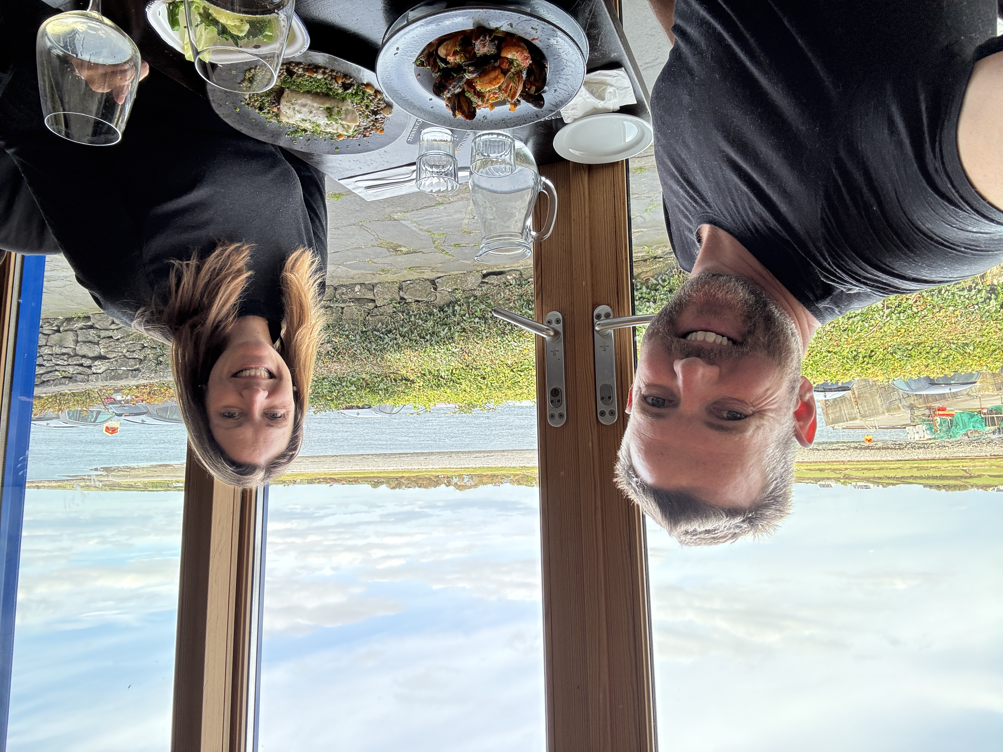 Couple enjoying seafood lunch with harbour view at restaurant on Aran Islands, Ireland