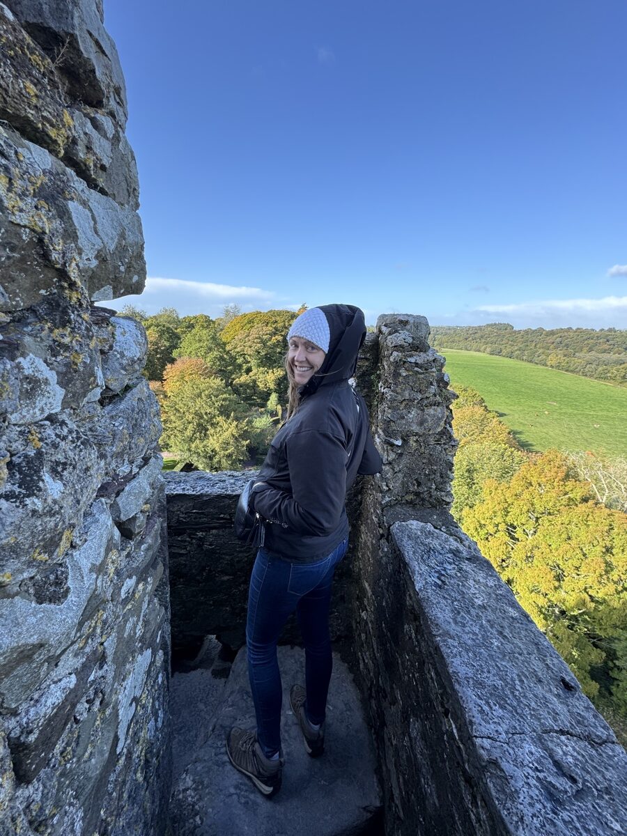 Dariece standing on the battlements at the top of Blarney Castle with autumn countryside views