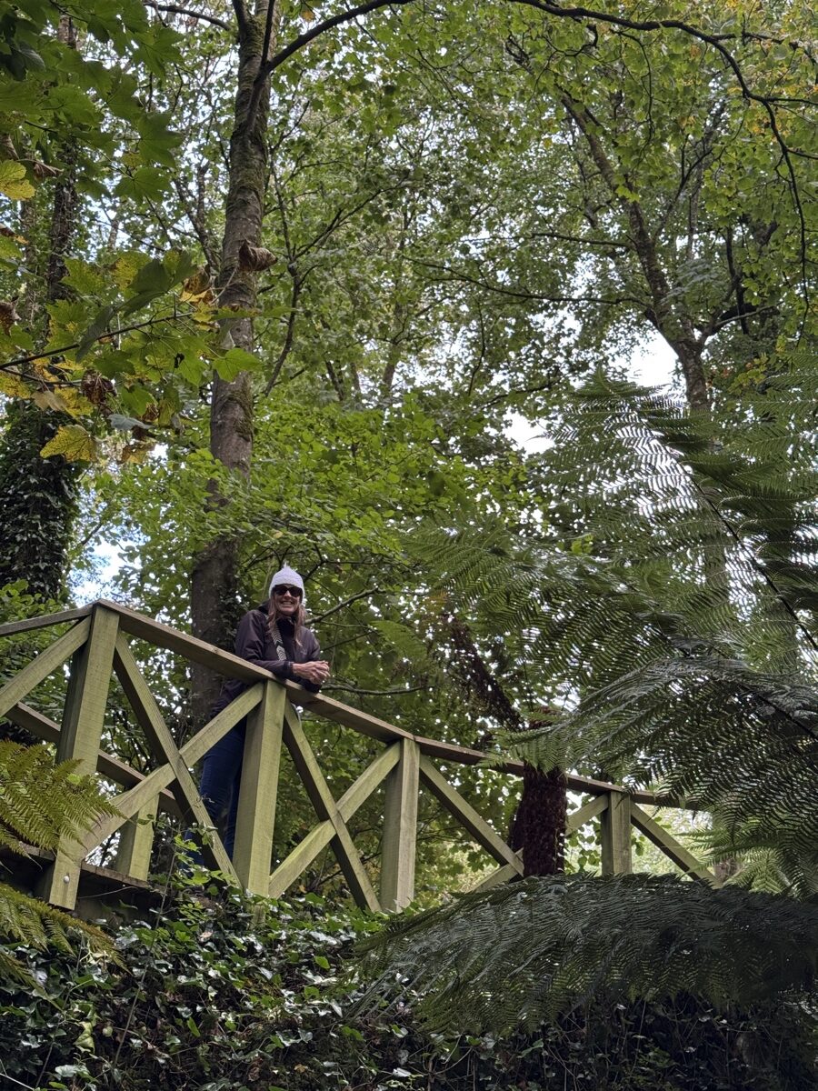 Dariece on the elevated wooden walkway through the lush Fern Garden at Blarney Castle