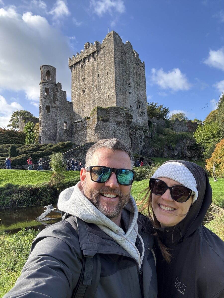 Nick and Dariece selfie in front of Blarney Castle tower on a sunny autumn day