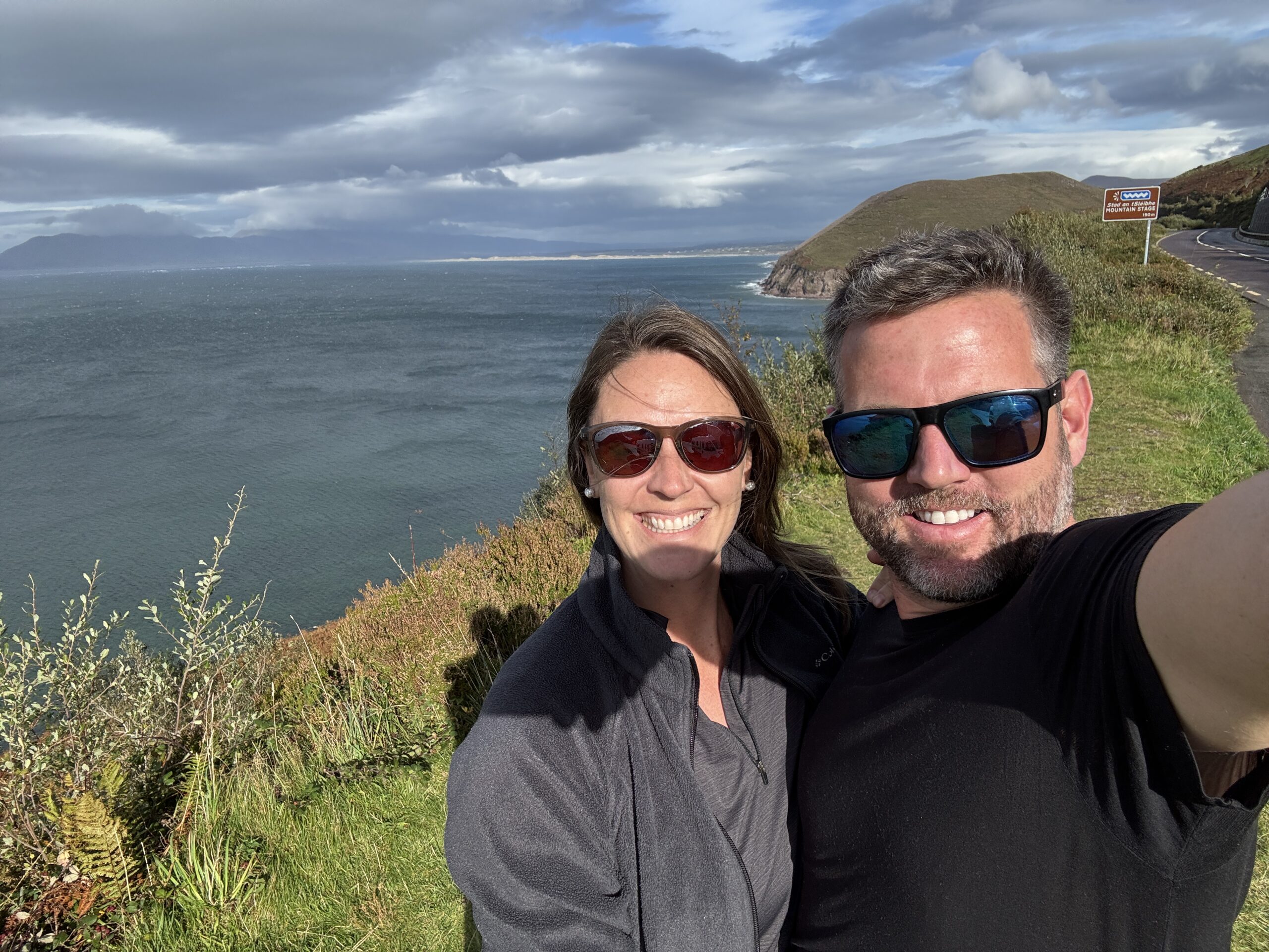 Nick and Dariece on the Ring of Kerry coastal road with the Atlantic Ocean behind them