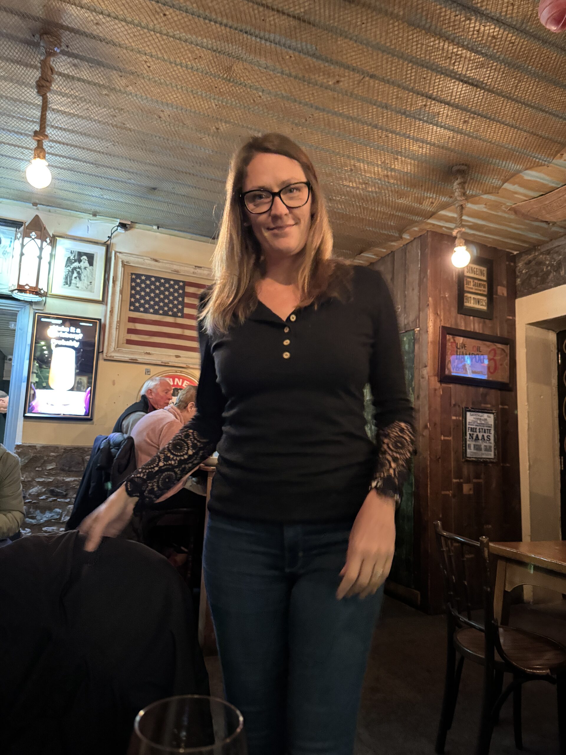 Woman smiling in a cosy traditional Irish pub in Dublin, Ireland