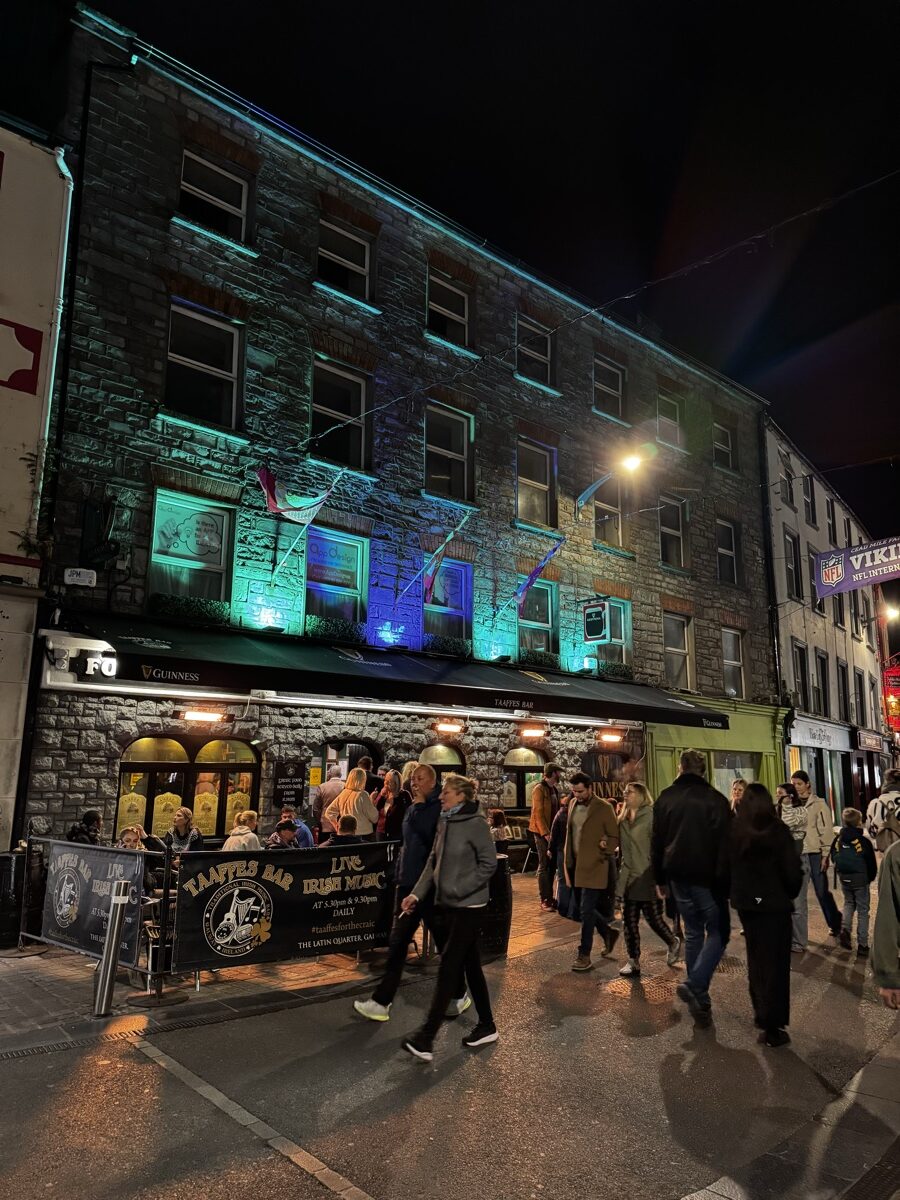 Taaffes Bar at night in the Latin Quarter of Galway, Ireland with crowds outside