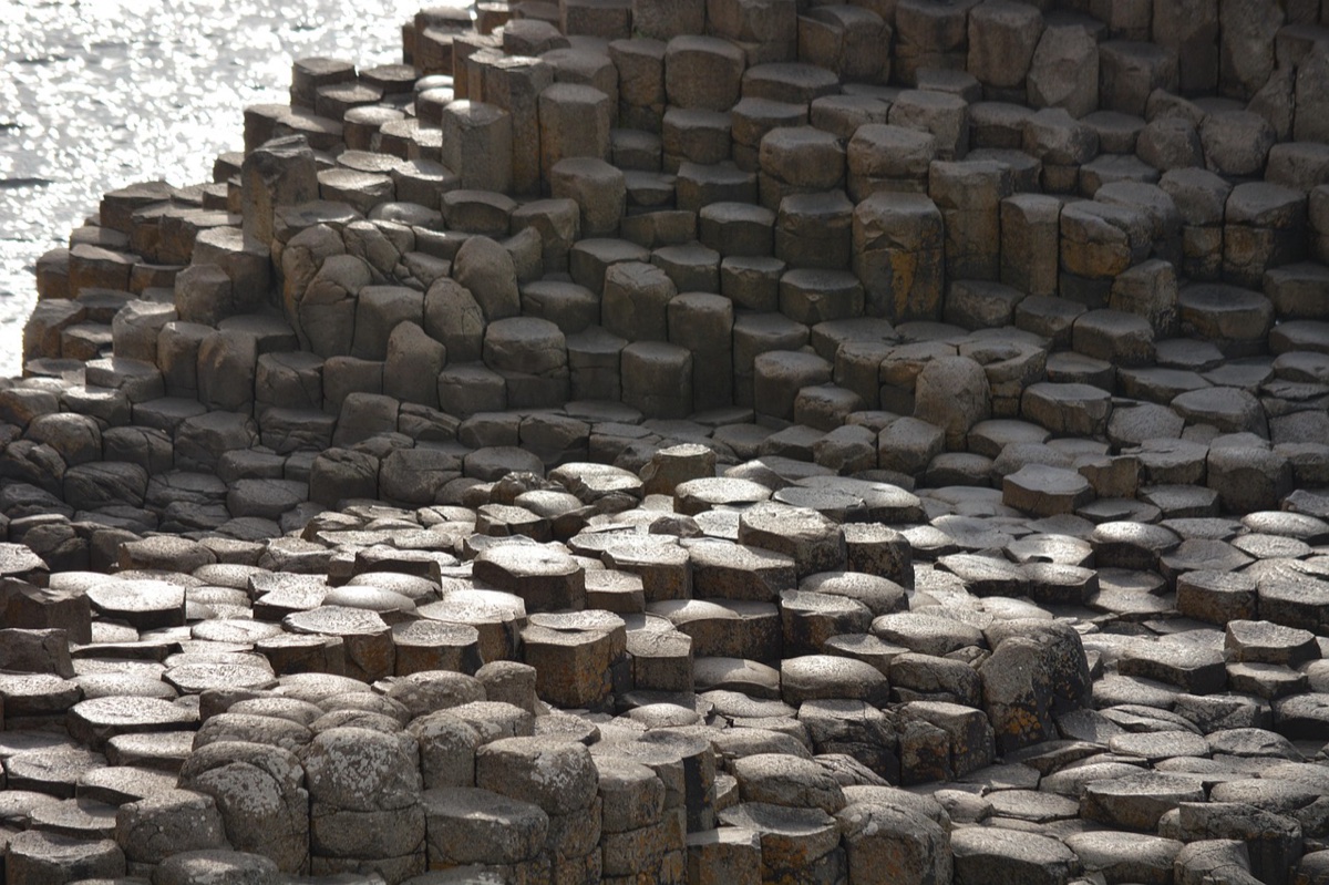 ancient basalt columns of the giant's causeway meeting the atlantic shore