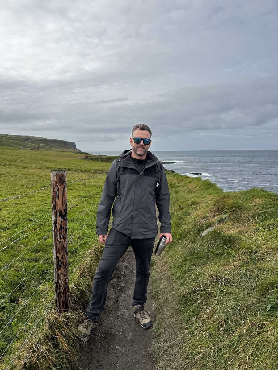 Nick in rain jacket on the coastal cliff path at the Cliffs of Moher, County Clare, Ireland