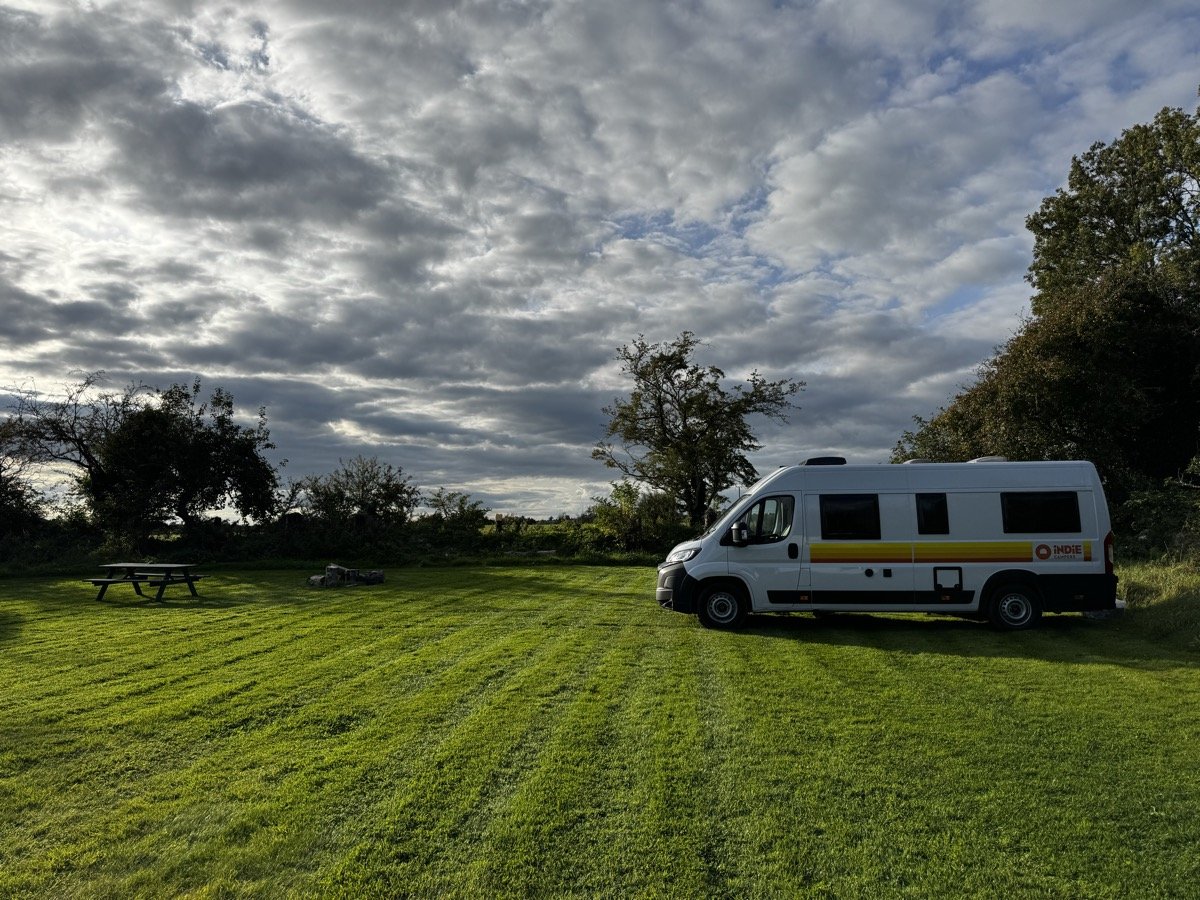 Campervan parked on grassy field with picnic table at Tua Campsite in Lorrha