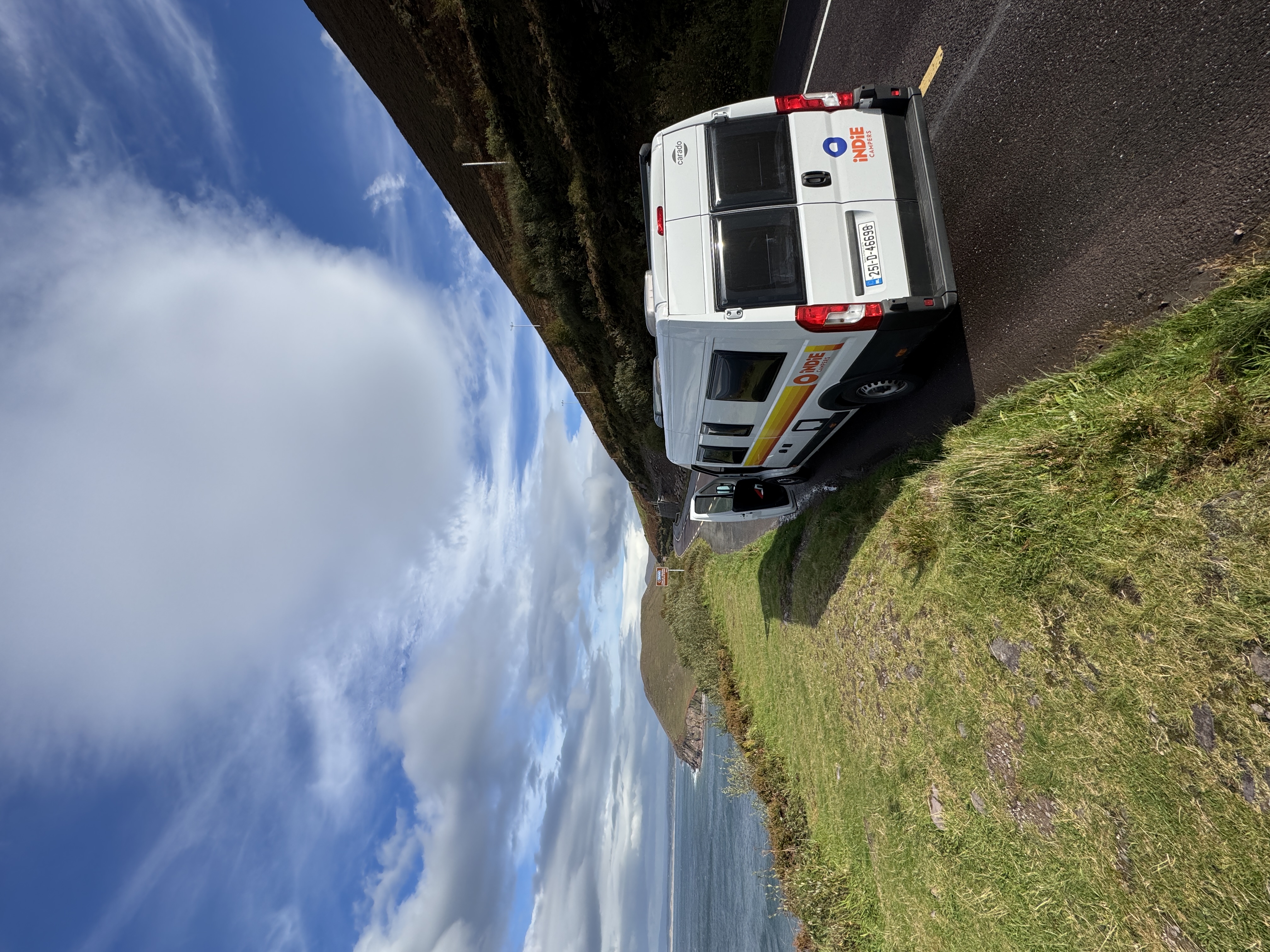 Campervan parked on the Ring of Kerry coastal road with dramatic sea and mountain views, Ireland