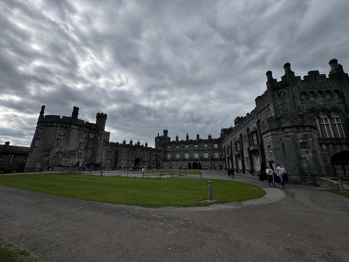 Kilkenny Castle exterior with grass courtyard under dramatic clouds