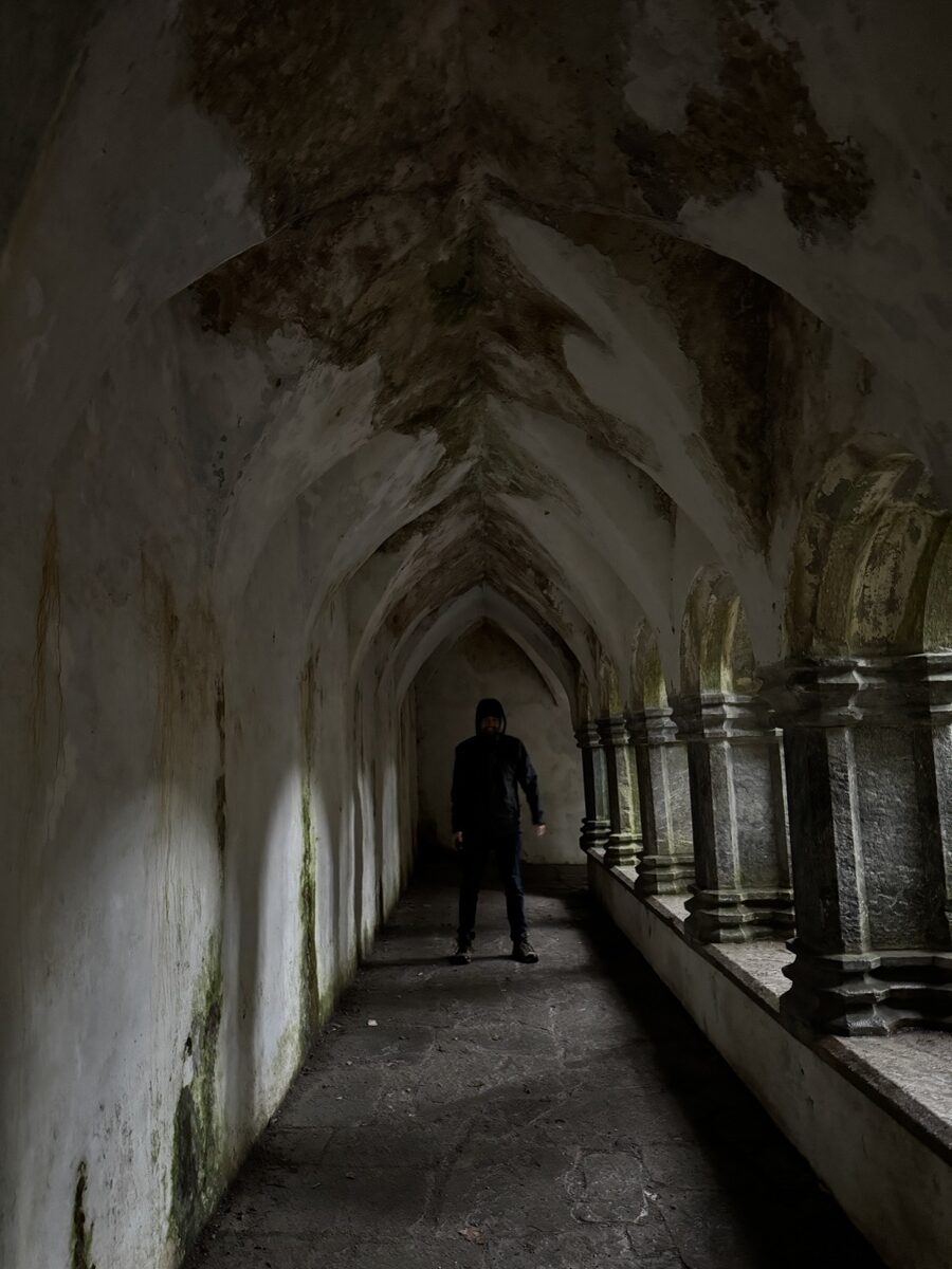 Nick exploring vaulted Gothic cloister at Muckross Abbey ruins in Killarney, Ireland