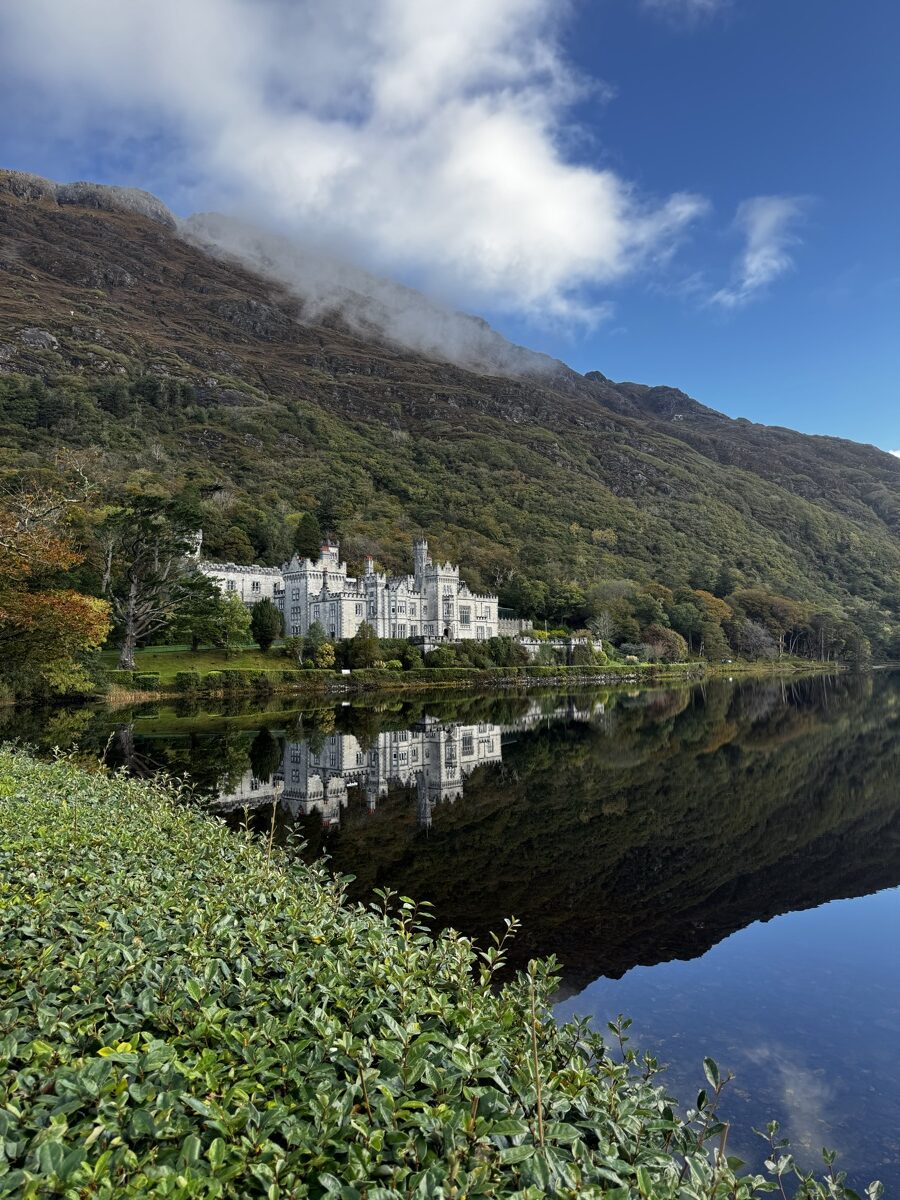 Kylemore Abbey and its perfect reflection in the still lake with Connemara mountains behind