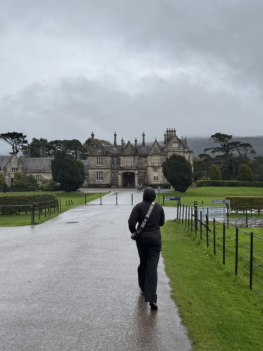Nick walking along the rain-soaked driveway toward Muckross House in Killarney National Park
