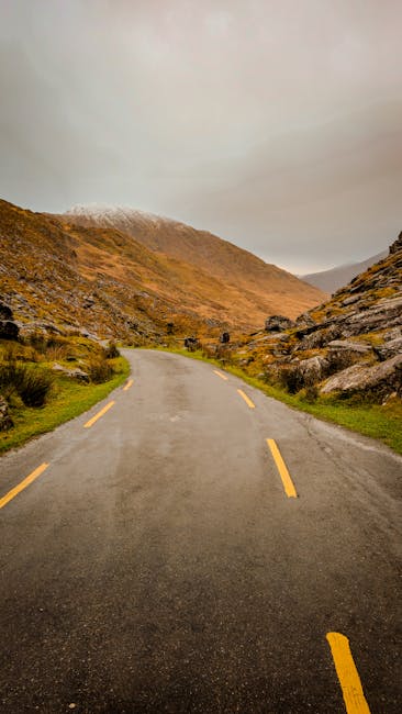 Serene mountain road in Killarney, Ireland, surrounded by rugged landscape and misty hills.
