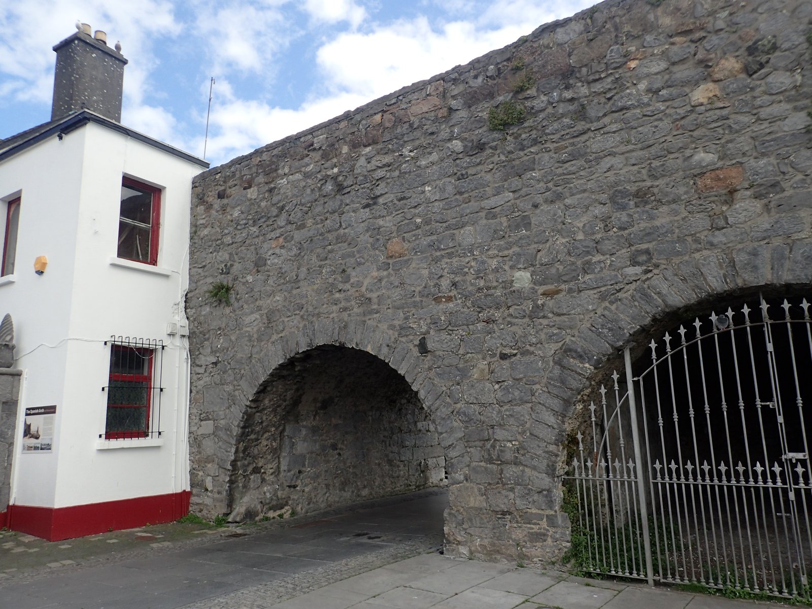 The Spanish Arch stone arch in Galway with a white building beside it
