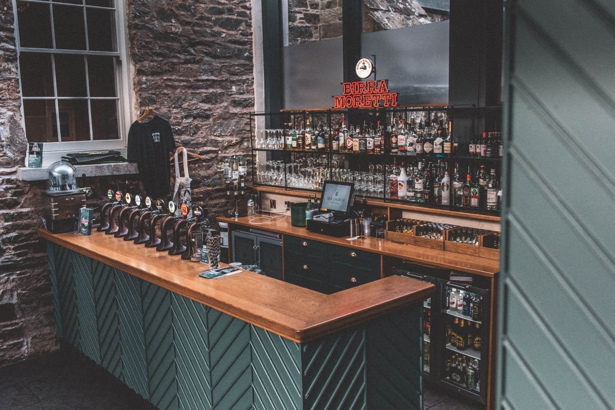 Dark stone Irish pub bar with a row of beer taps