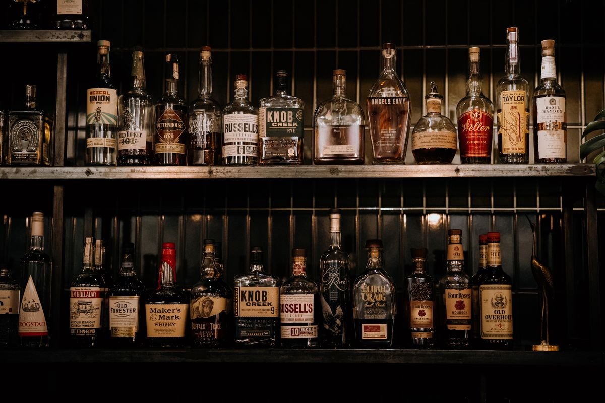 Back bar shelves stacked with whiskey bottles