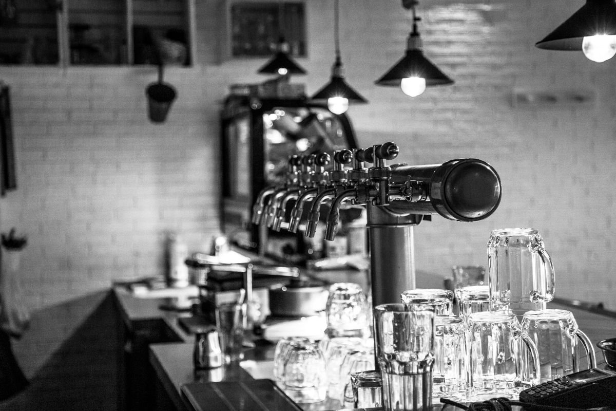Row of beer taps and pint glasses on a pub bar