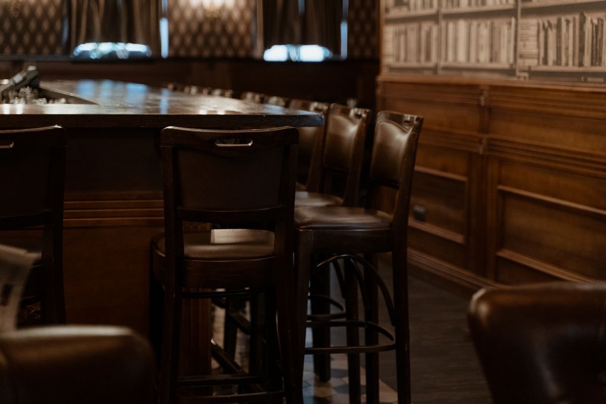 Dark wood pub snug with leather bar stools