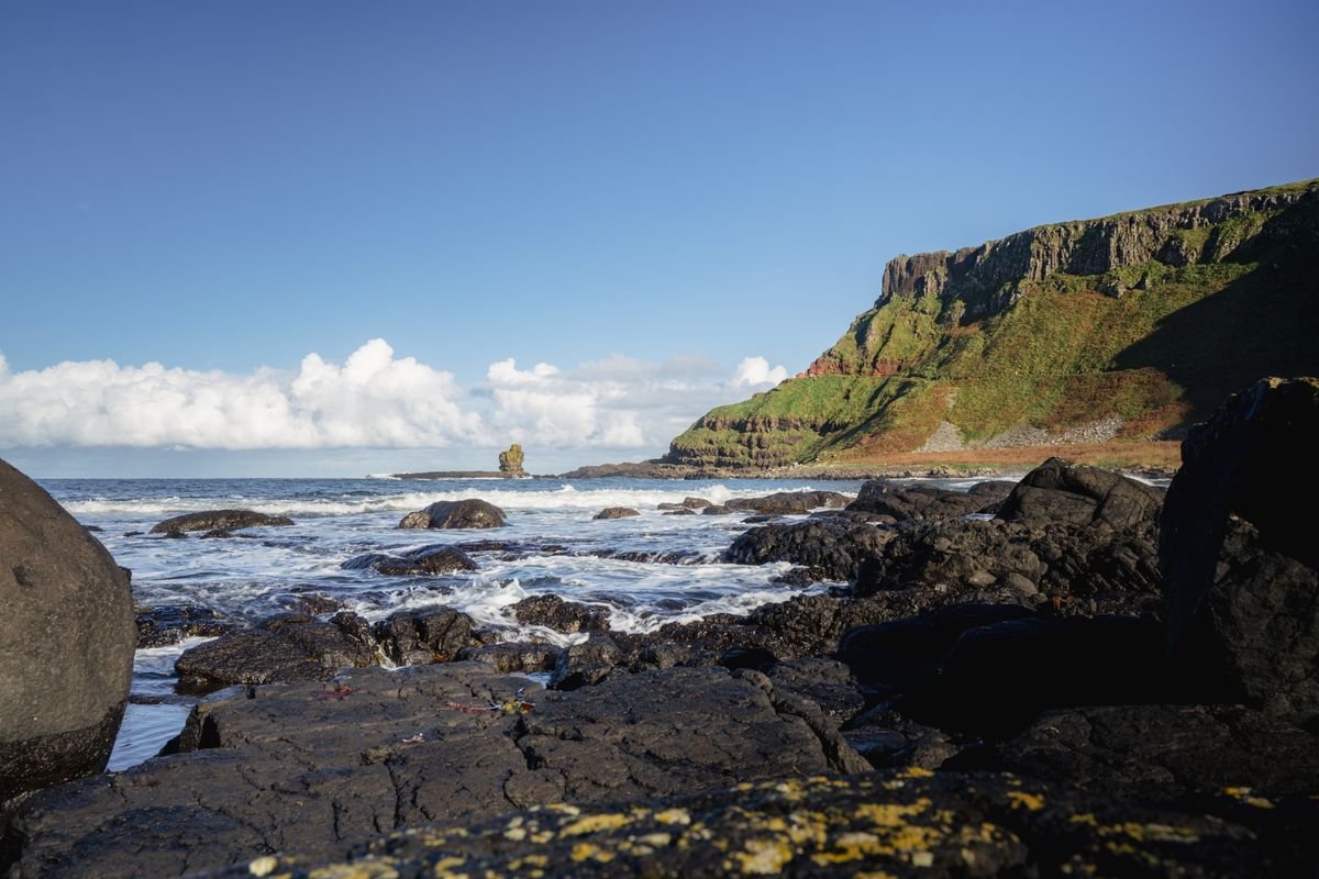 Sunny rocky shore and sea stack on the Antrim coast