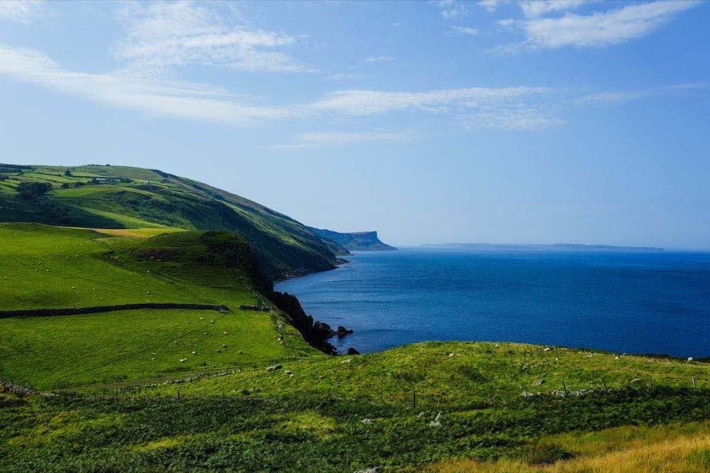 Green coastal hills and blue sea on a clear summer day in Donegal