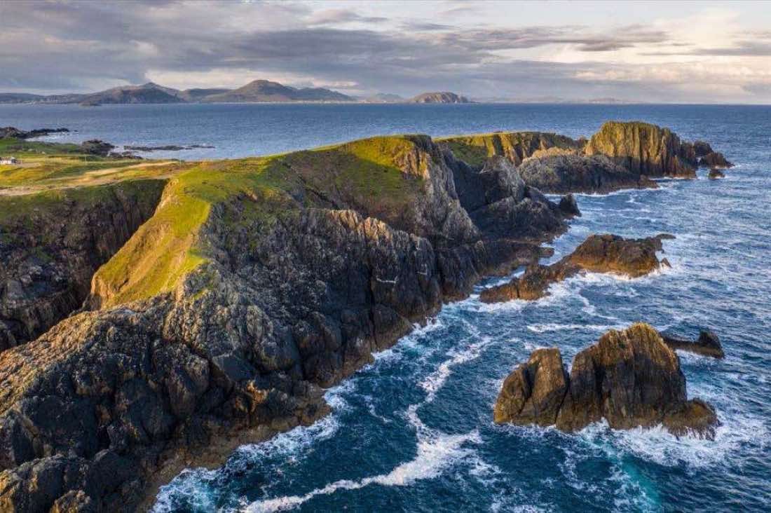 Golden evening light on the Malin Head headland and sea stacks