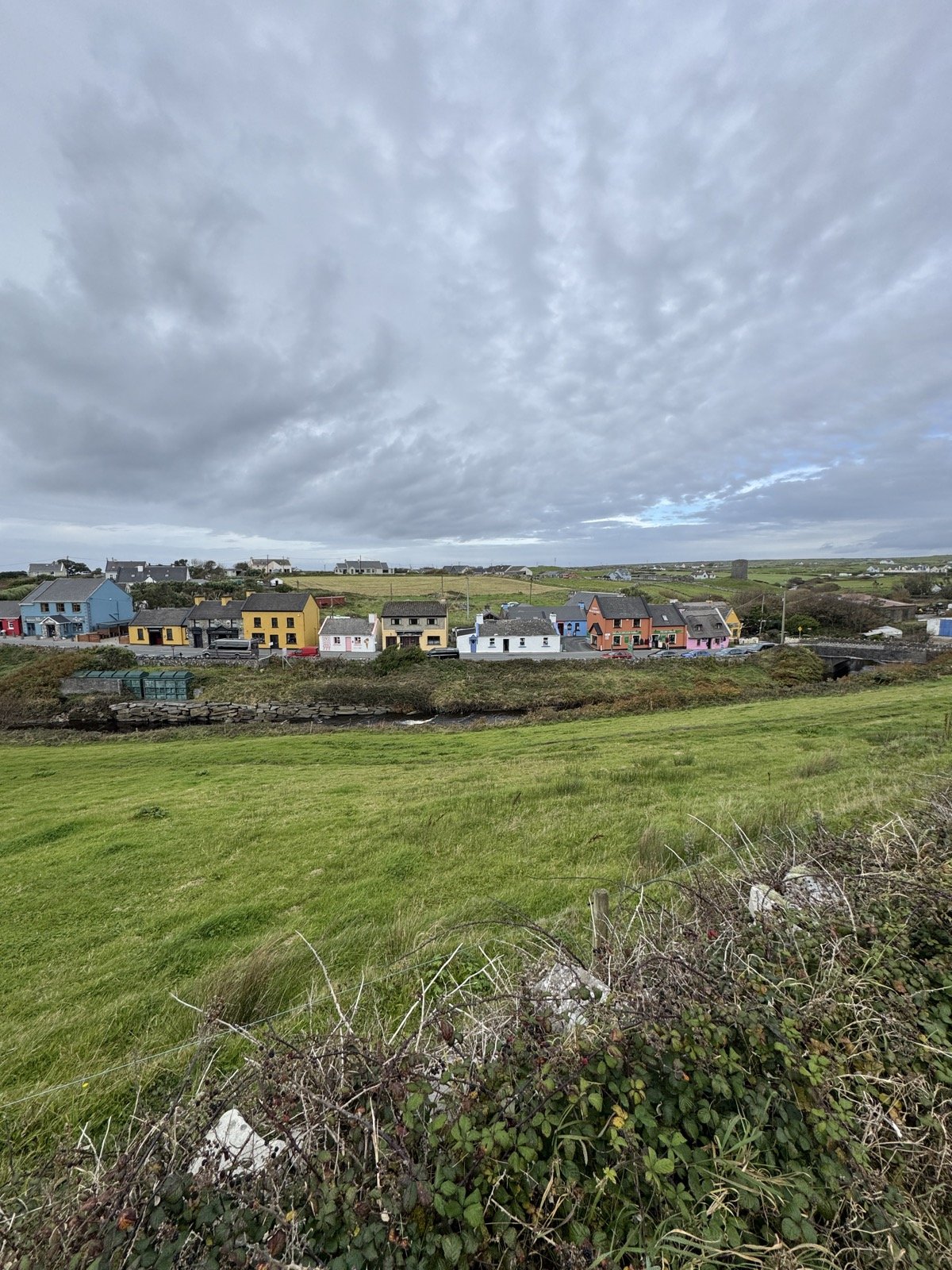 View over the colourful houses of Doolin village from the hill above, County Clare