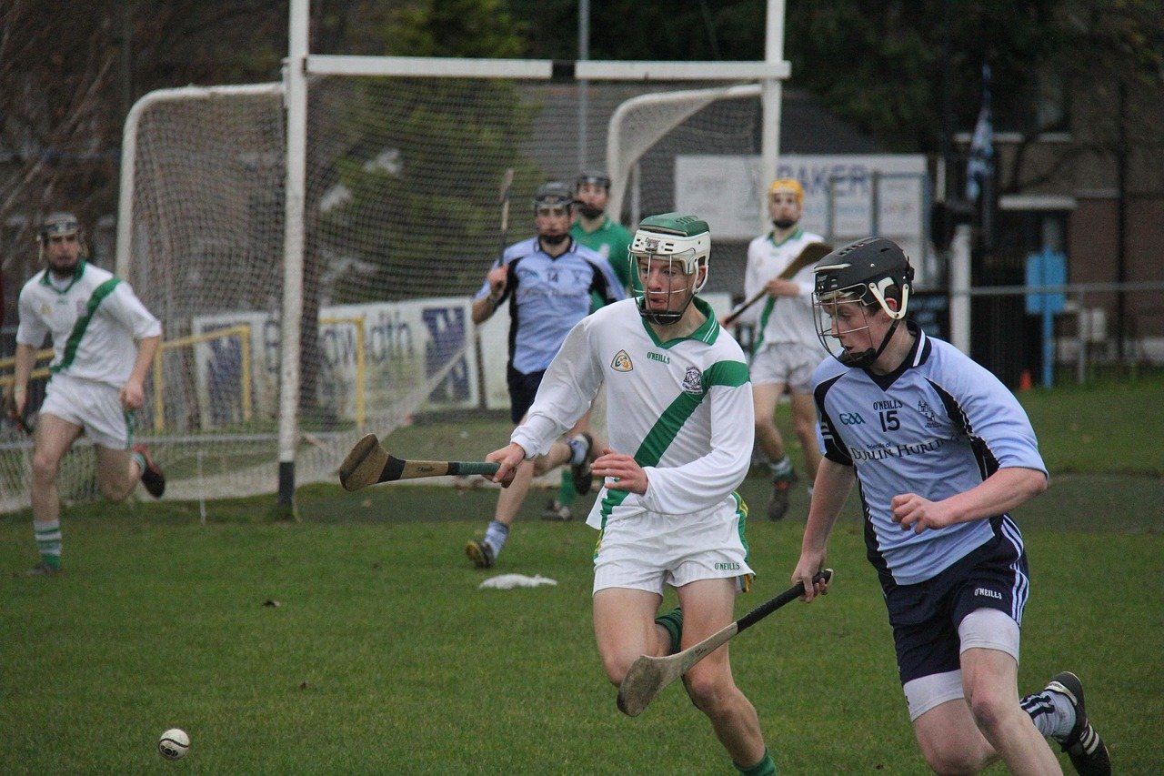 Hurlers from two counties chasing the sliotar during a GAA match in Ireland
