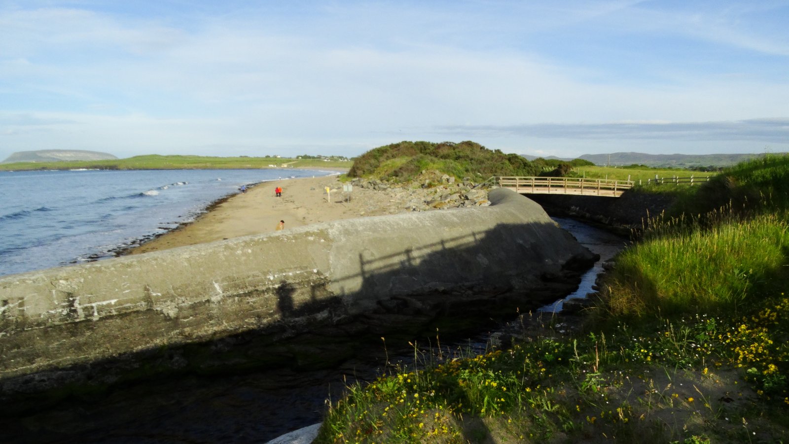 Wide flat sand at low tide on Dunmoran Strand in Sligo, hills in the distance.