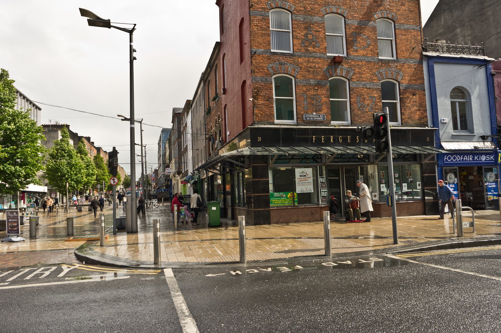 A street corner with shops and pedestrians in Limerick city centre