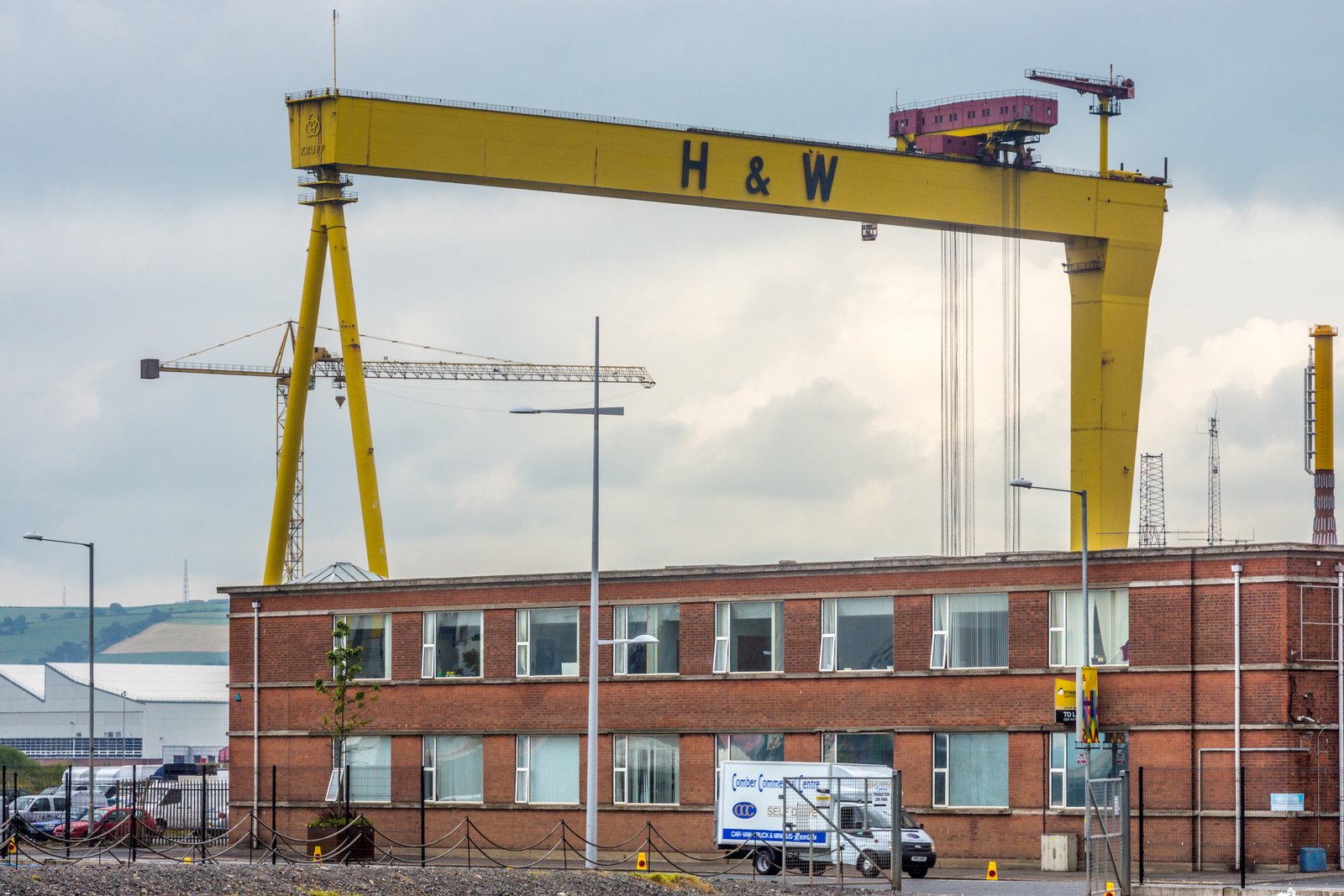 Yellow Harland and Wolff crane above the old red-brick shipyard offices in Belfast