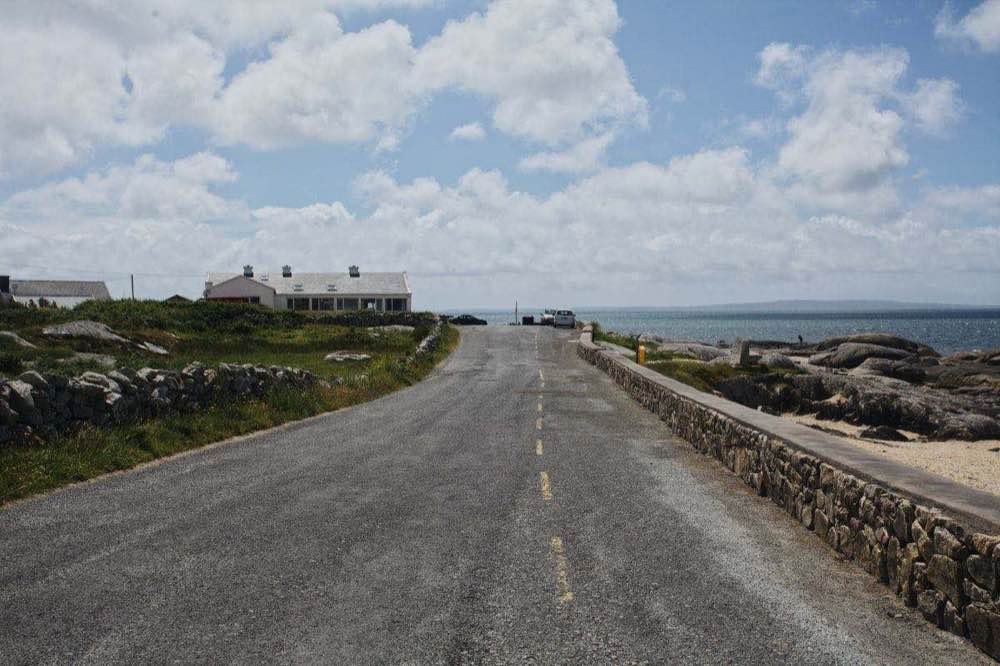 A narrow rural road with a stone wall on the Donegal coast