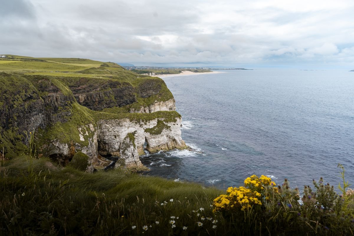 White limestone sea cliffs above a curving sandy beach on the Causeway Coast