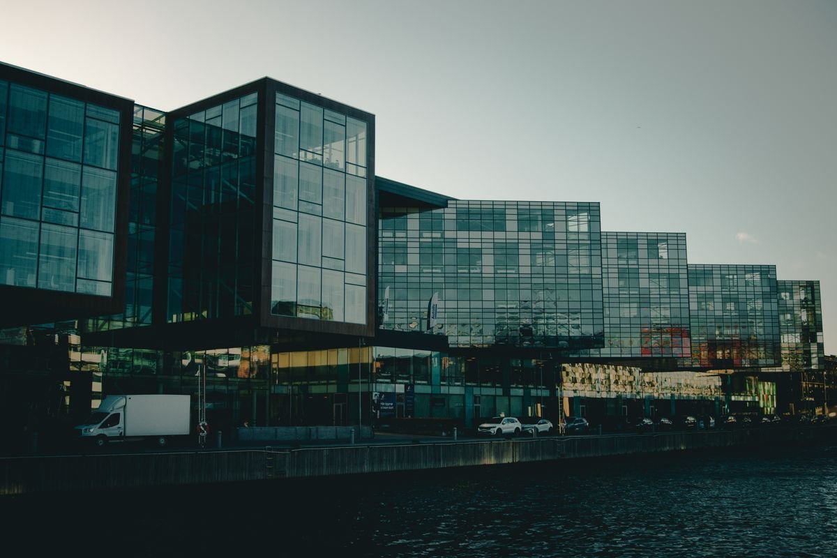 Modern glass office buildings on a waterfront at dusk