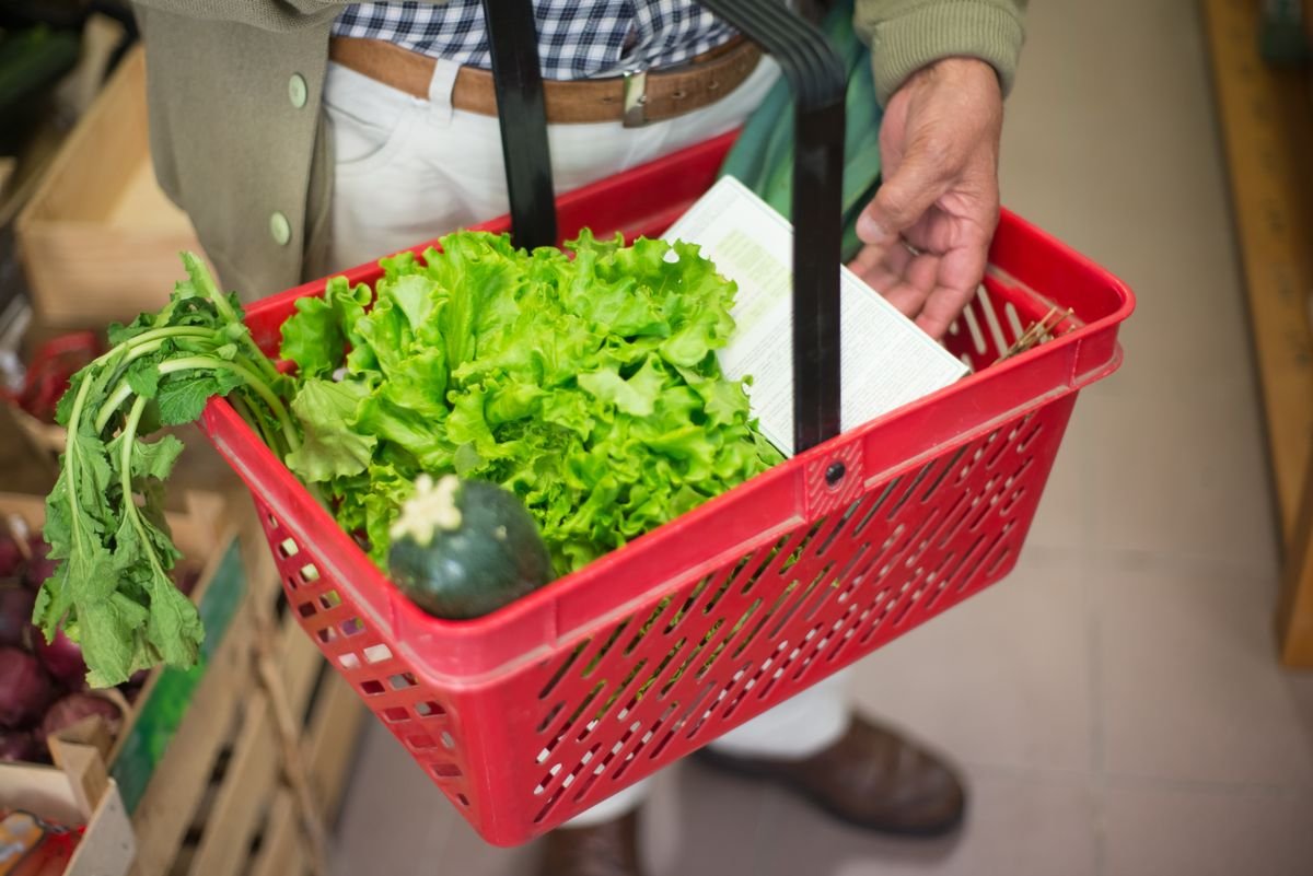 A shopping basket of fresh vegetables held in an Irish grocery shop