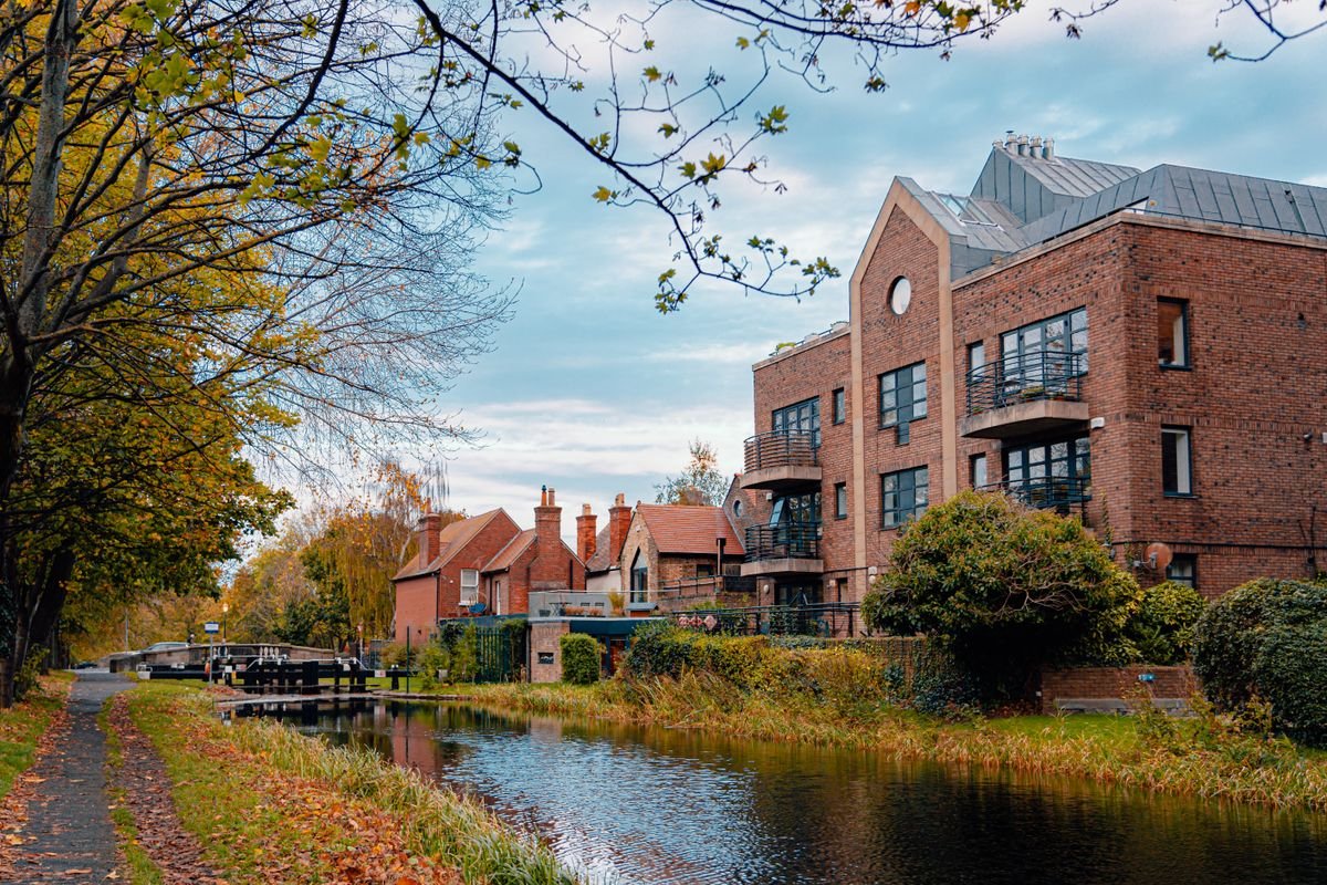 Apartments along a quiet Dublin canal with a lock and autumn trees