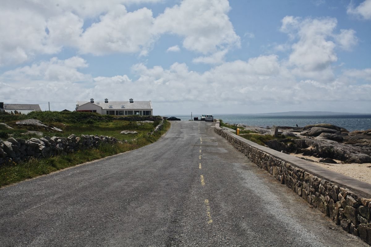 An empty coastal road with a stone wall and the Atlantic in the west of Ireland