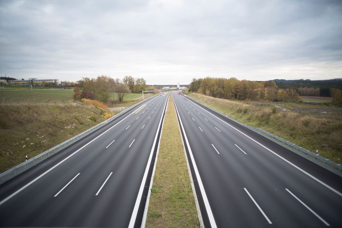 A wide multi-lane motorway receding into the Irish countryside