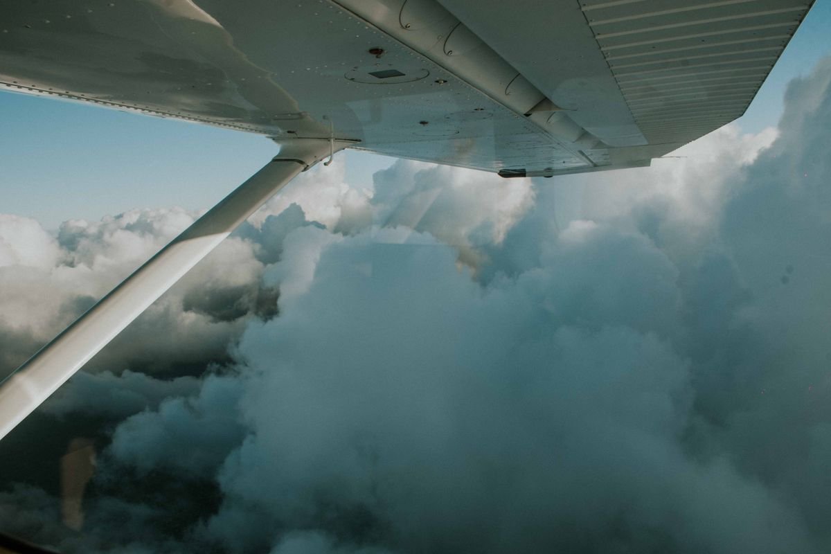 A small aircraft wing above the clouds in flight