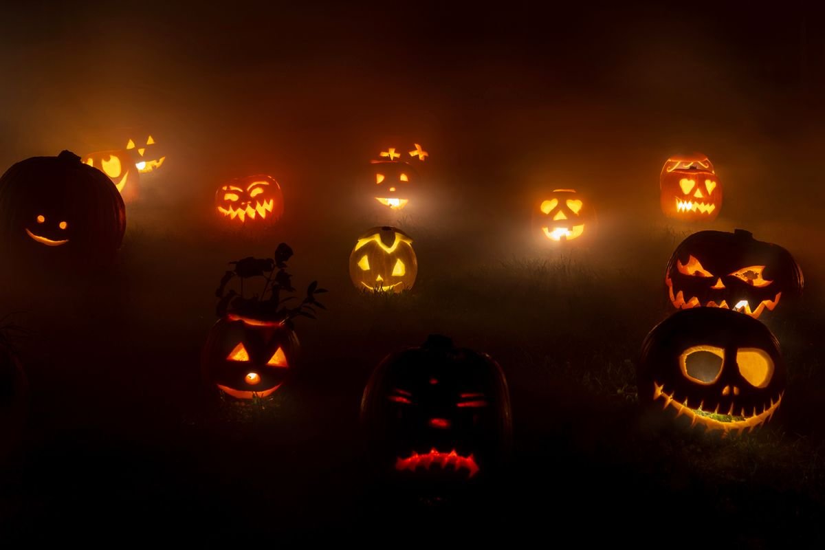 Carved Halloween pumpkins glowing at night in the fog