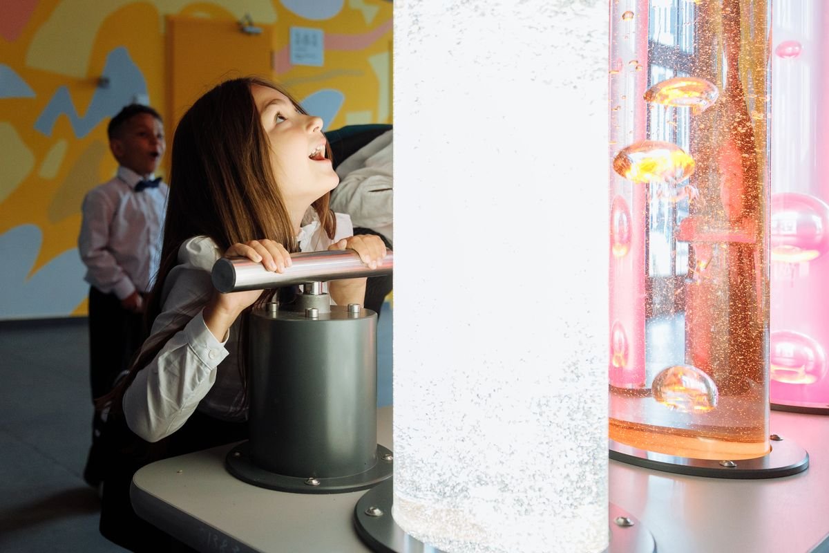 Child at an interactive science exhibit at a discovery centre
