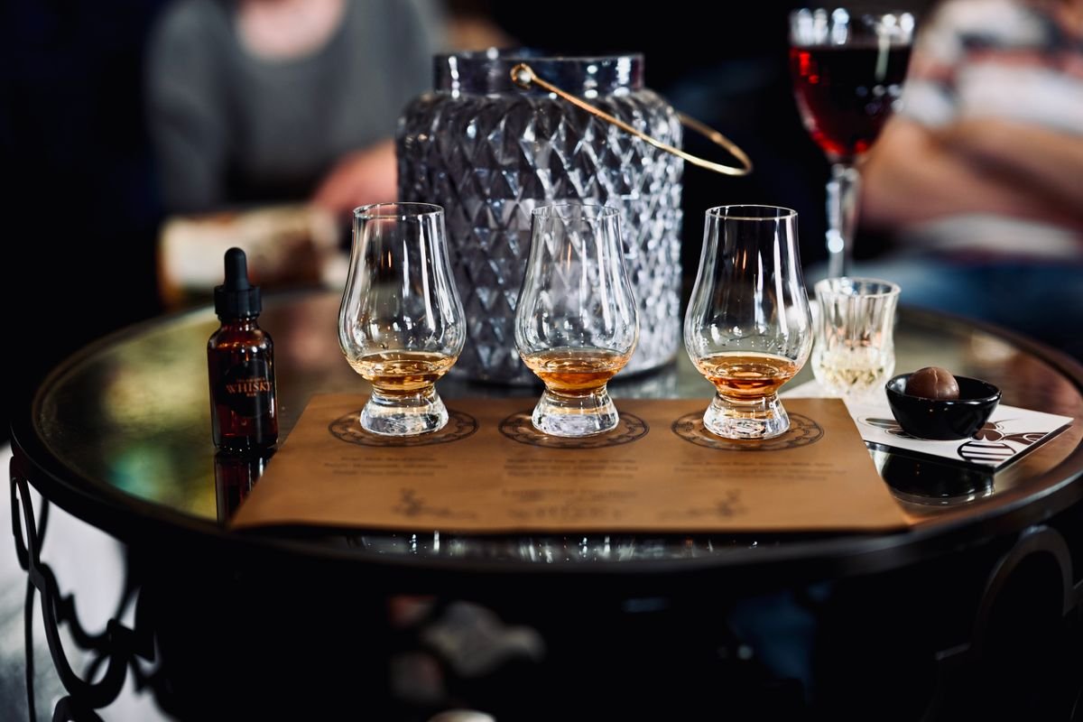 A whiskey tasting flight of three glasses on a table