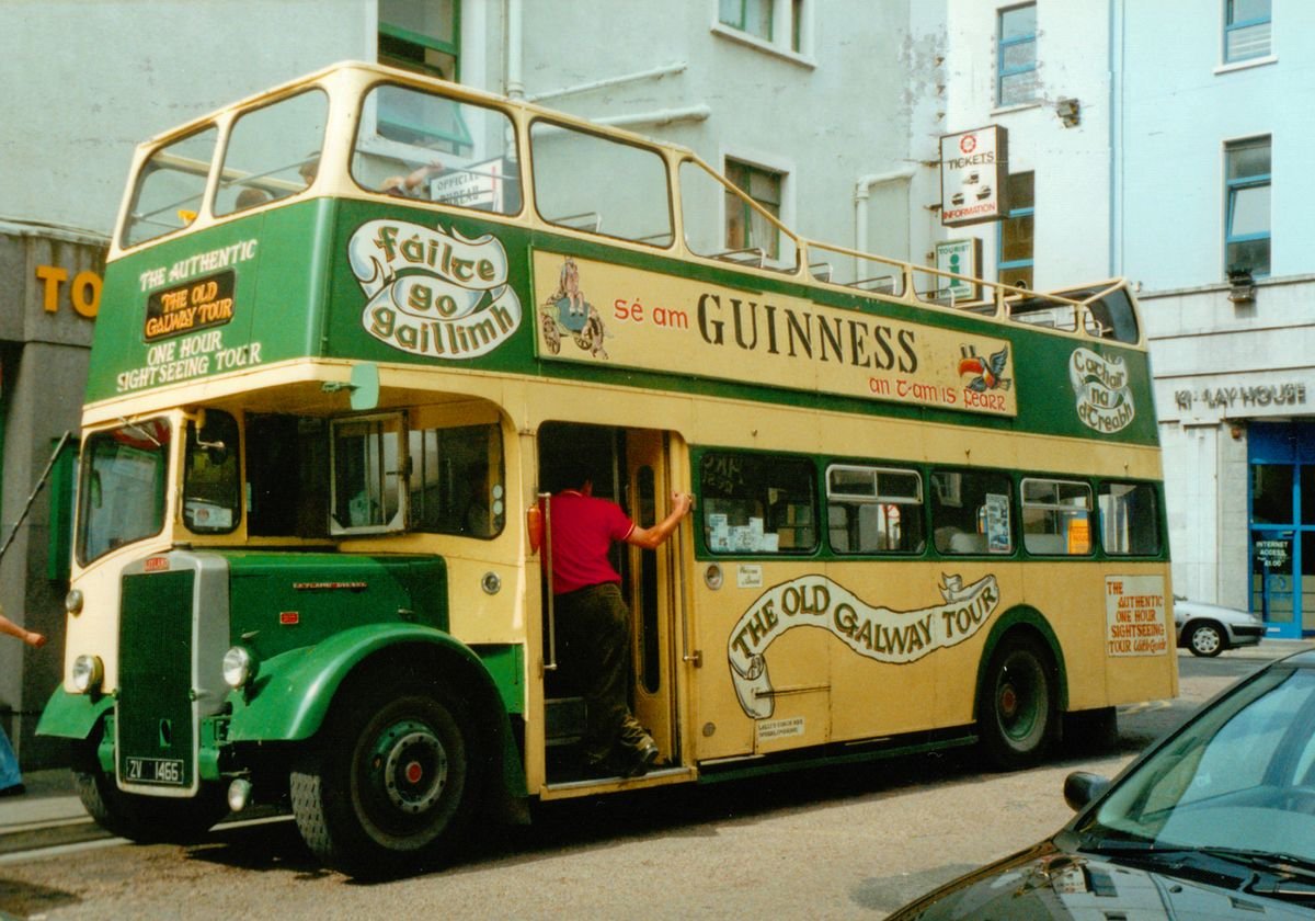 An open-top Irish tour bus parked on a town street