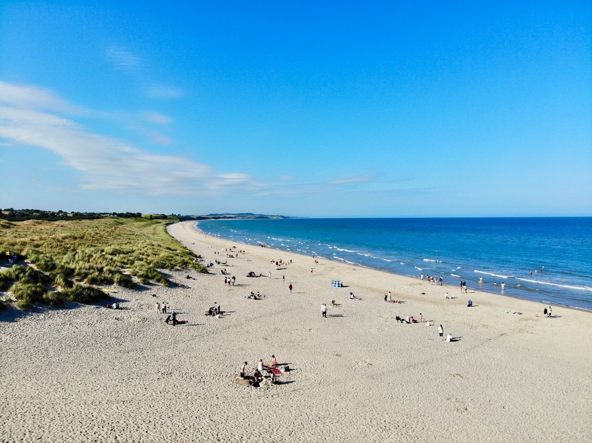 Busy Irish beach with families on the sand on a sunny day