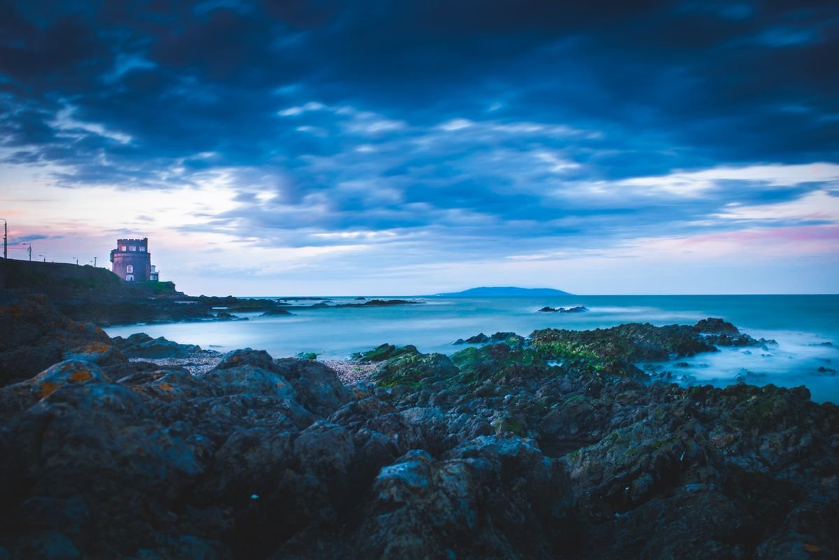 A coastal tower under a long summer dusk sky in Ireland