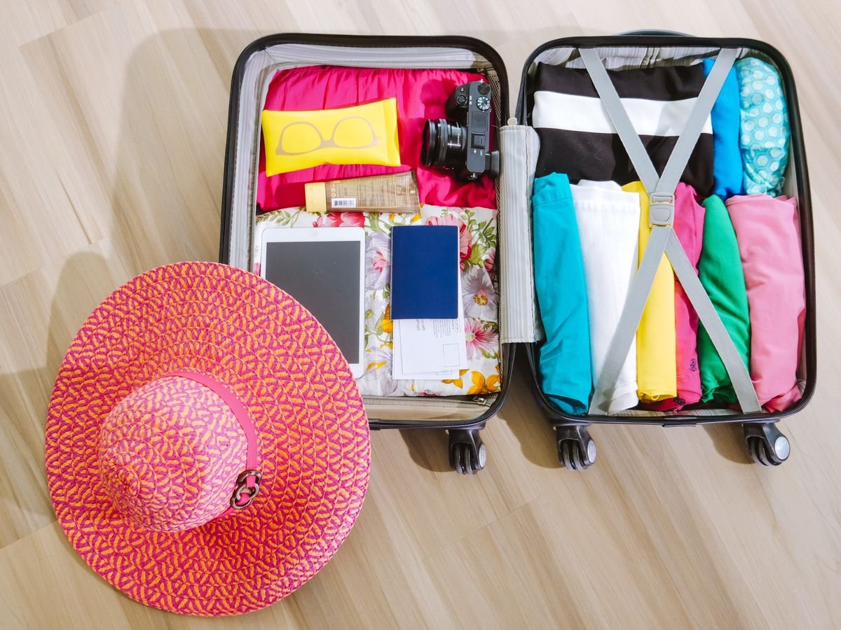 An open suitcase packed with layers for a trip